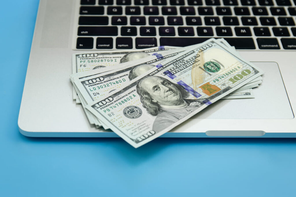 UK beginner working on laptop and smartphone showing the top 10 best side hustles to earn money online and offline in 2026